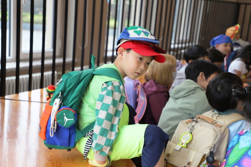 a boy wearing multiple caps