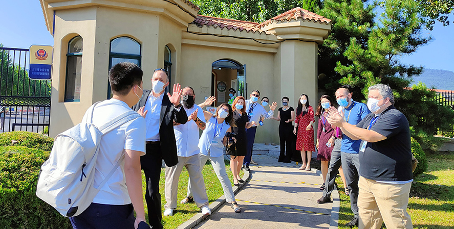 Teachers greet students at the entrance