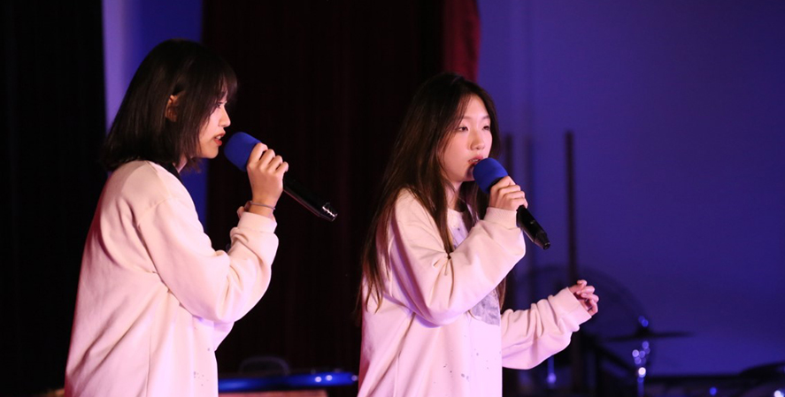 Two high school girls singing